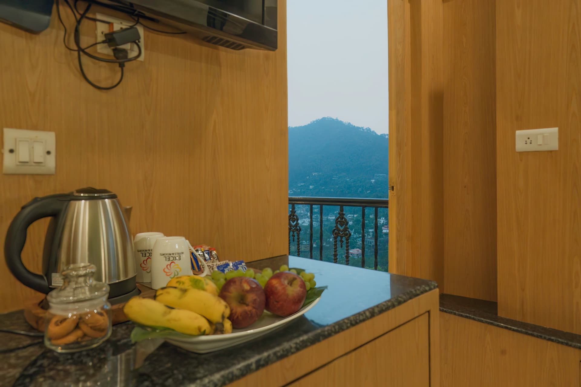 Premium Room refreshment counter with fruit platter and a view towards the Bhimtal hills