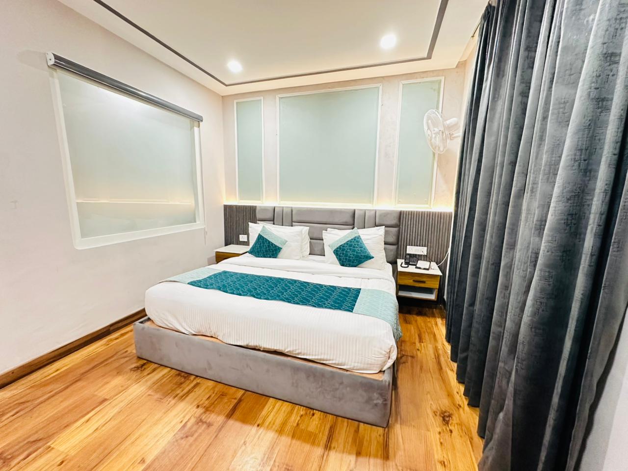 Family Suite master king bedroom with grey headboard and teal accents at Excel Hotels Nainital