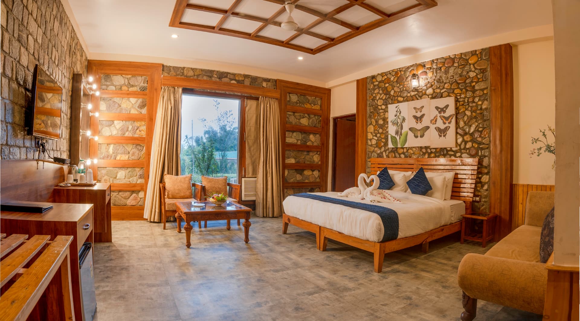 SplitsVilla bedroom at The Banyan Retreat with seating area and warm interiors
