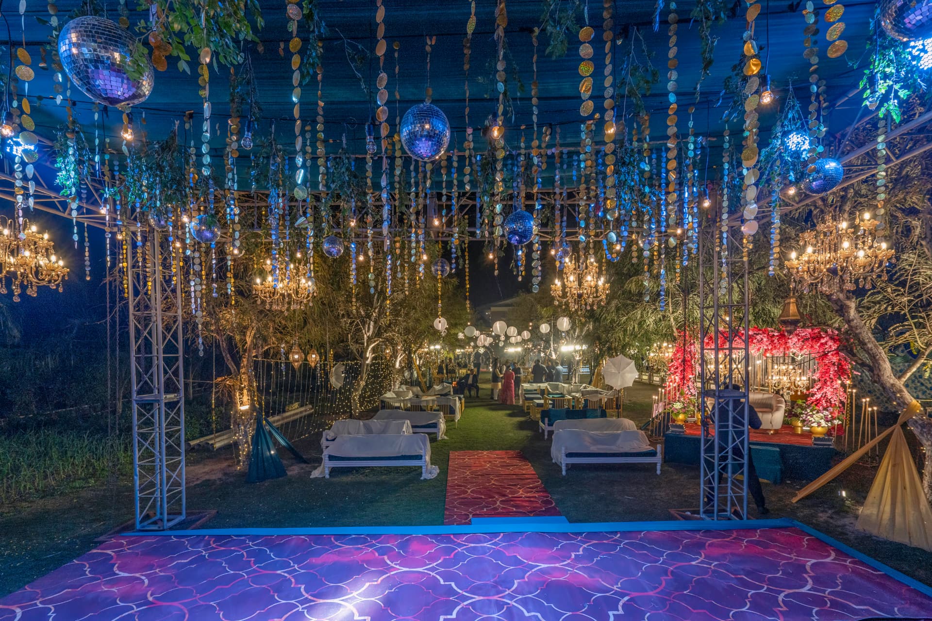 Sangeet dance floor with disco balls, chandeliers and colourful lighting at Excel Hotels & Resorts, Corbett
