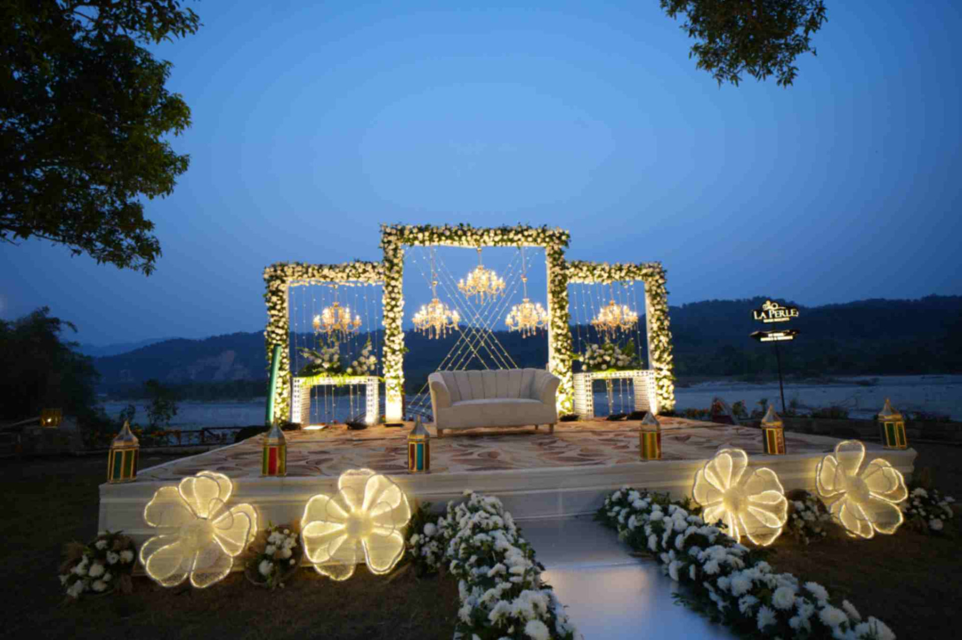 Illuminated floral wedding stage beside the river at La Perle River Resort