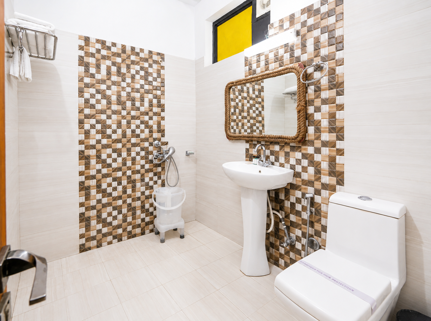 Bathroom with mosaic tiling, rope-framed mirror and shower in the Leopard Lair room
