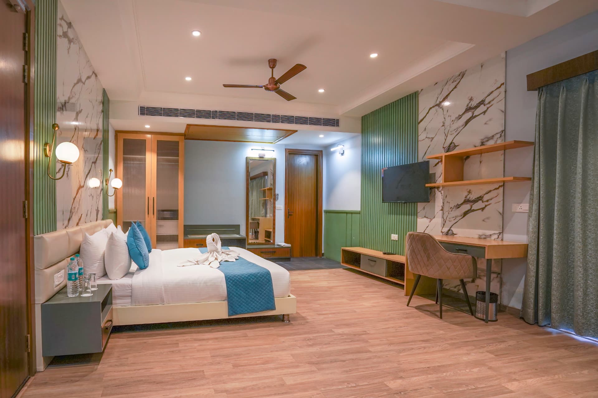Supreme Room with king bed, green fluted panels and study desk