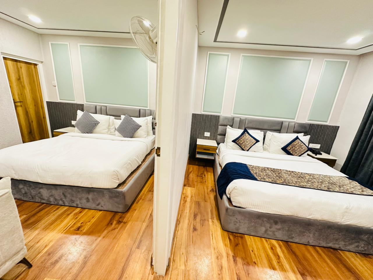 Family Suite second view of two connected king bedrooms with wooden flooring at Excel Hotels Nainital