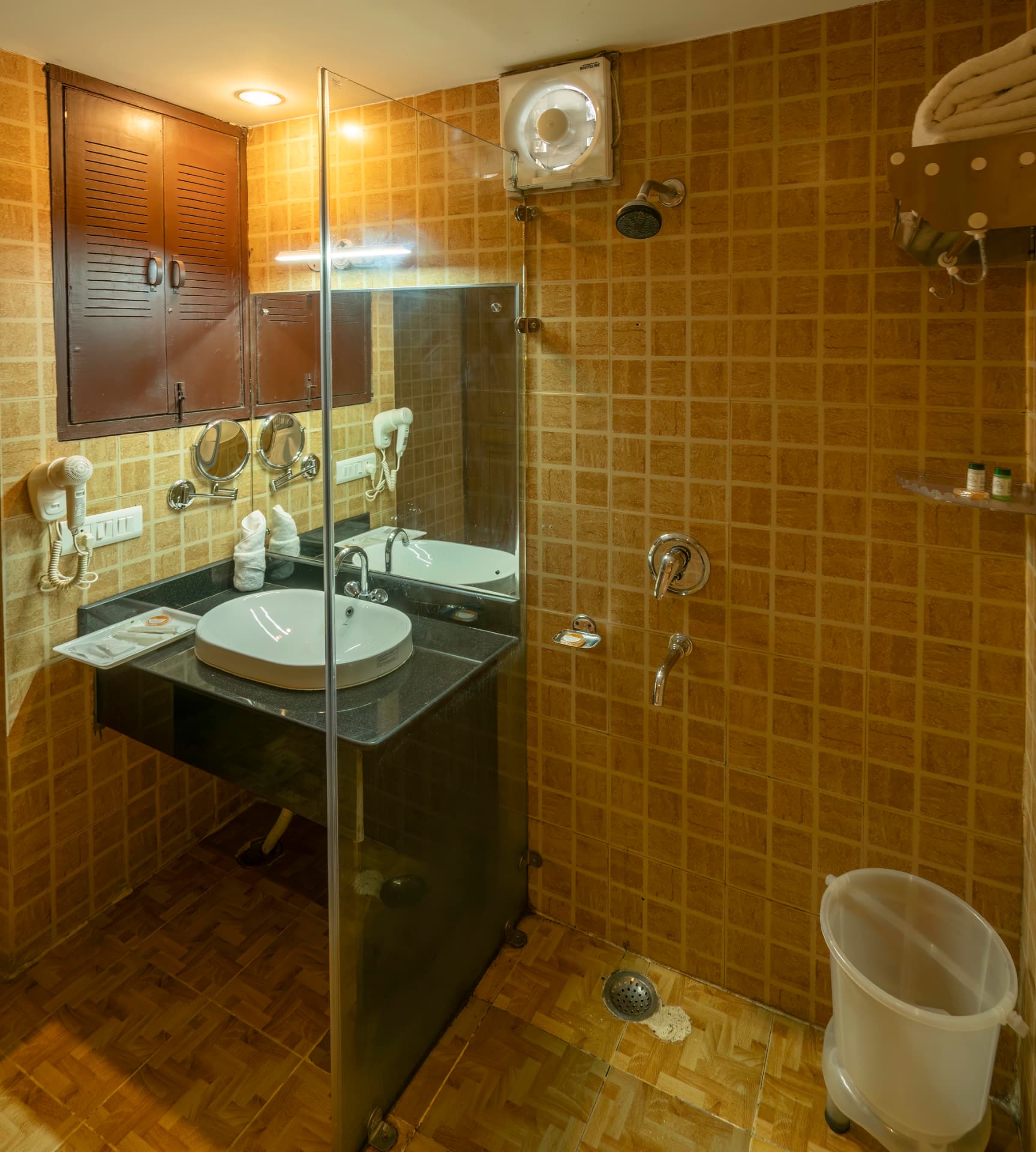 Family Cottage bathroom with shower cubicle, vanity and warm tiles at Excel Hotels & Resorts Bhimtal