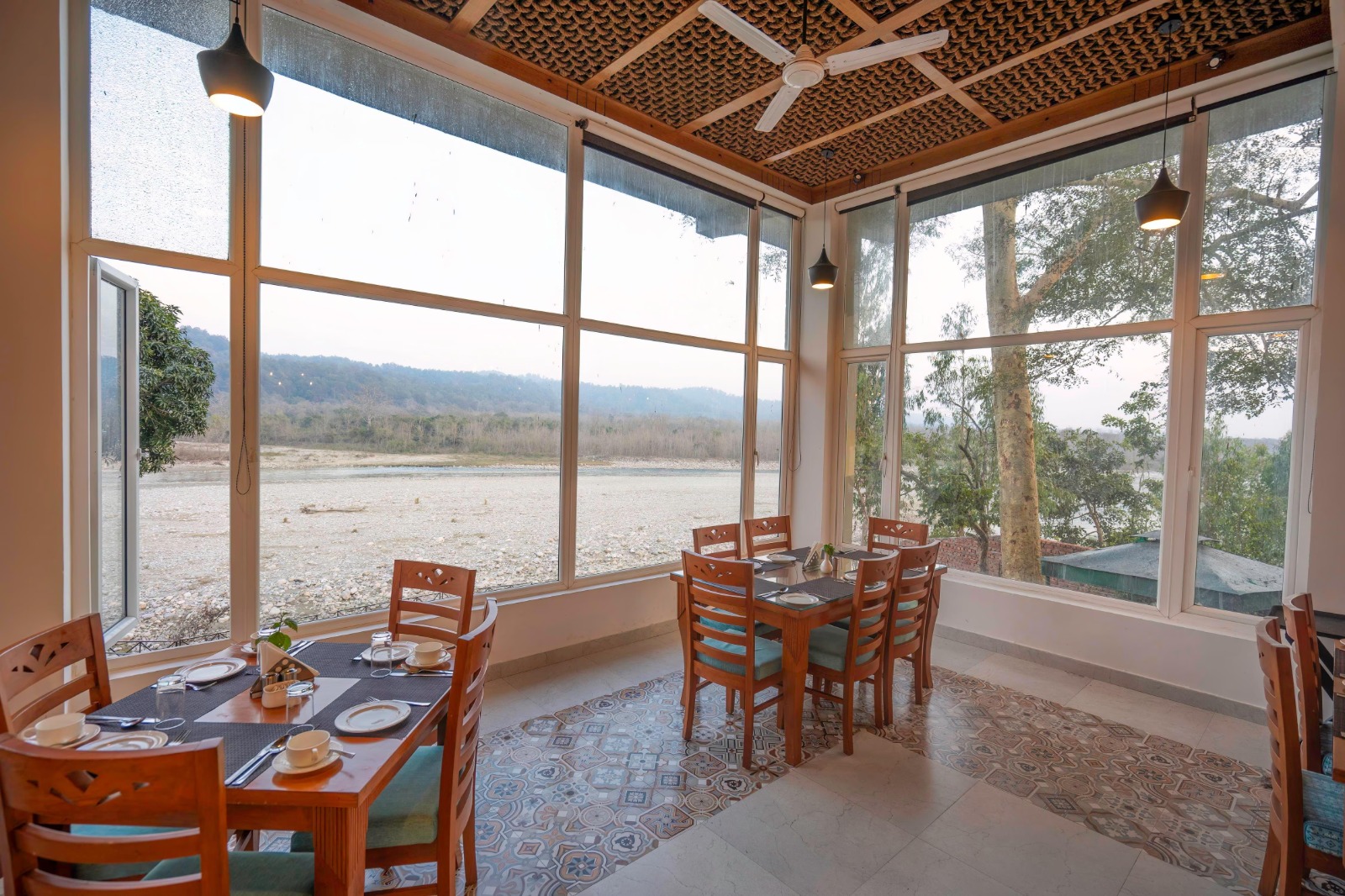 Riverside Dining table set beside the Kosi river at La Perle River Resort, Jim Corbett