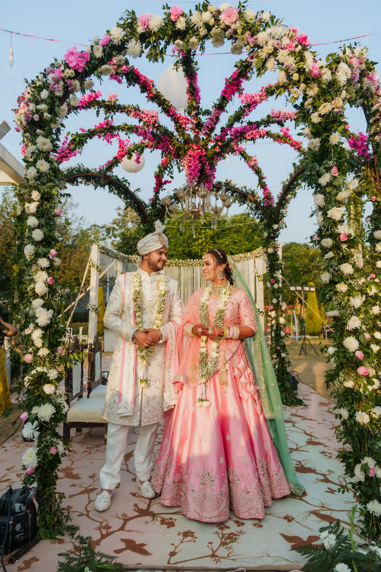 Bride and groom under a pink and white floral mandap at The Banyan Retreat Jim Corbett