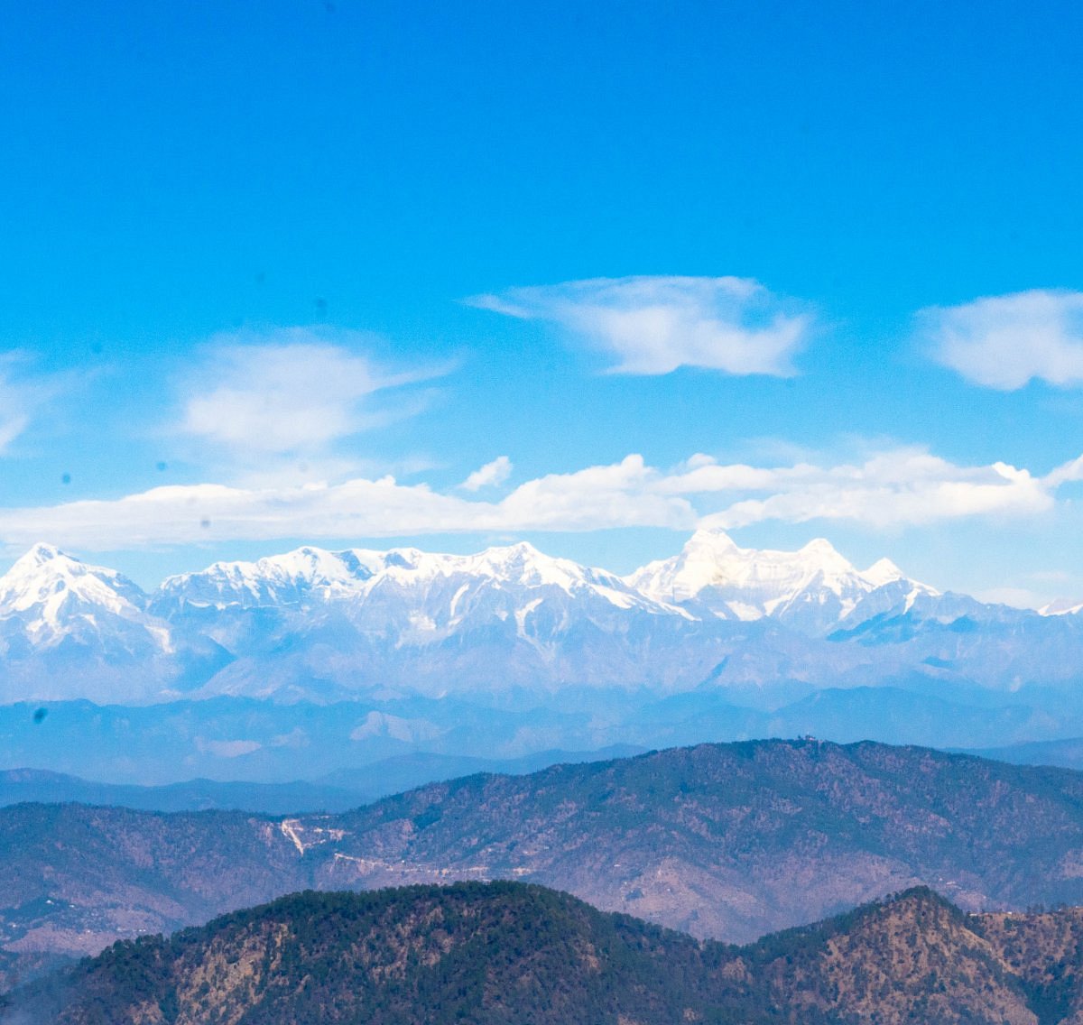 Snow-covered Himalayan mountain range viewed from Snow View Point above the forested Nainital hills