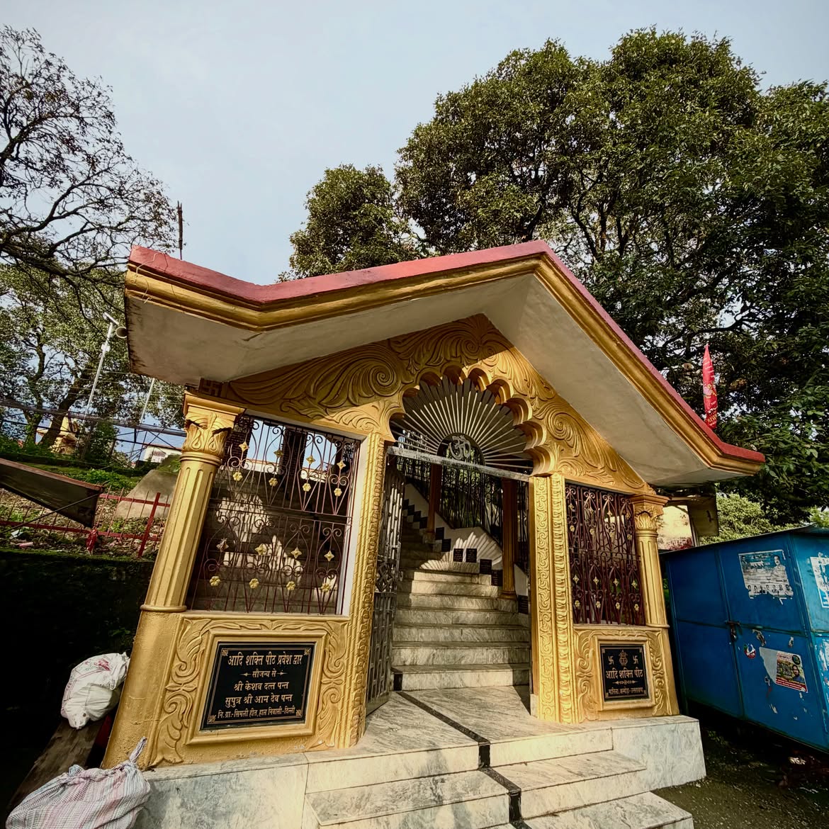 Ornate golden temple gateway with marble steps at Manila Devi Temple