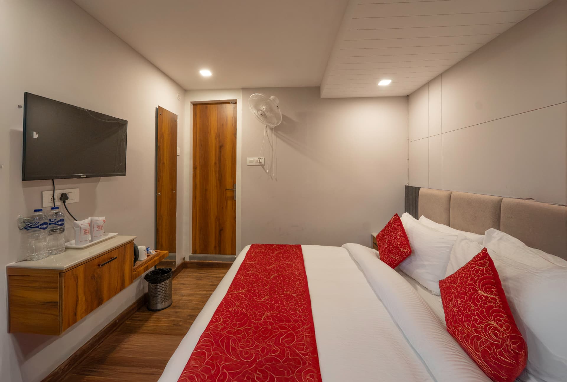 Deluxe Lake View Room interior with red bedding and wardrobe at Excel Hotels Nainital