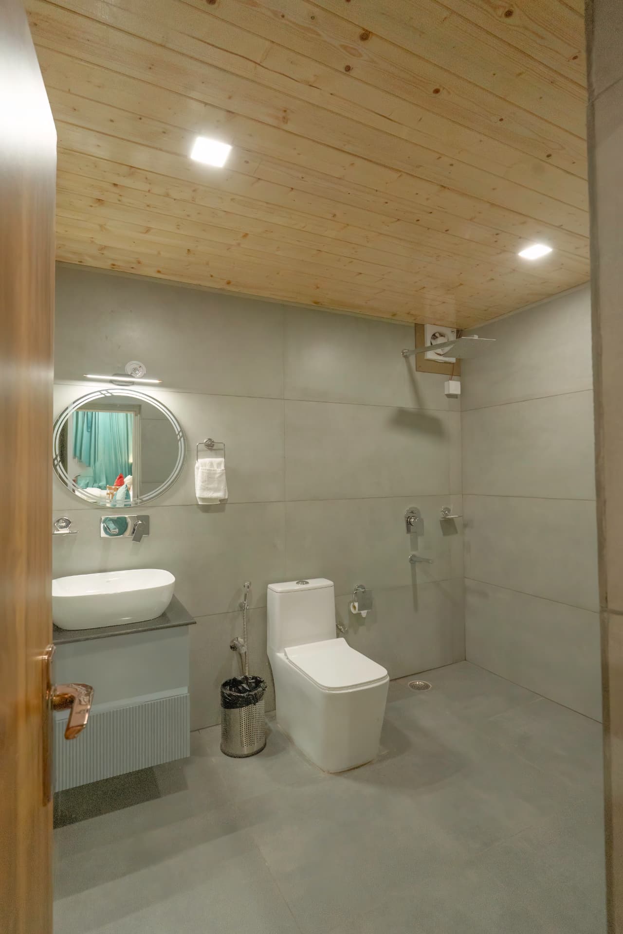 Family Suite modern bathroom with wooden ceiling, vessel sink, round mirror and shower at Excel Hotels Nainital