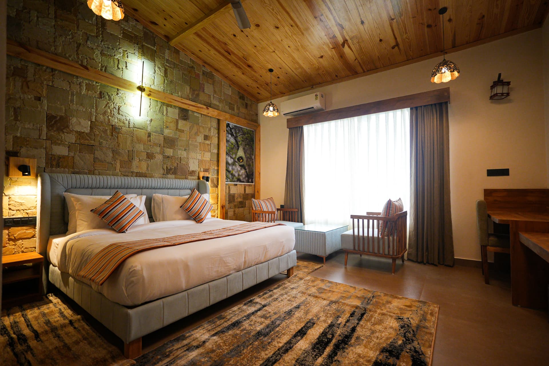 Wide view of the Weaver Bird Room with double bed, seating and garden window