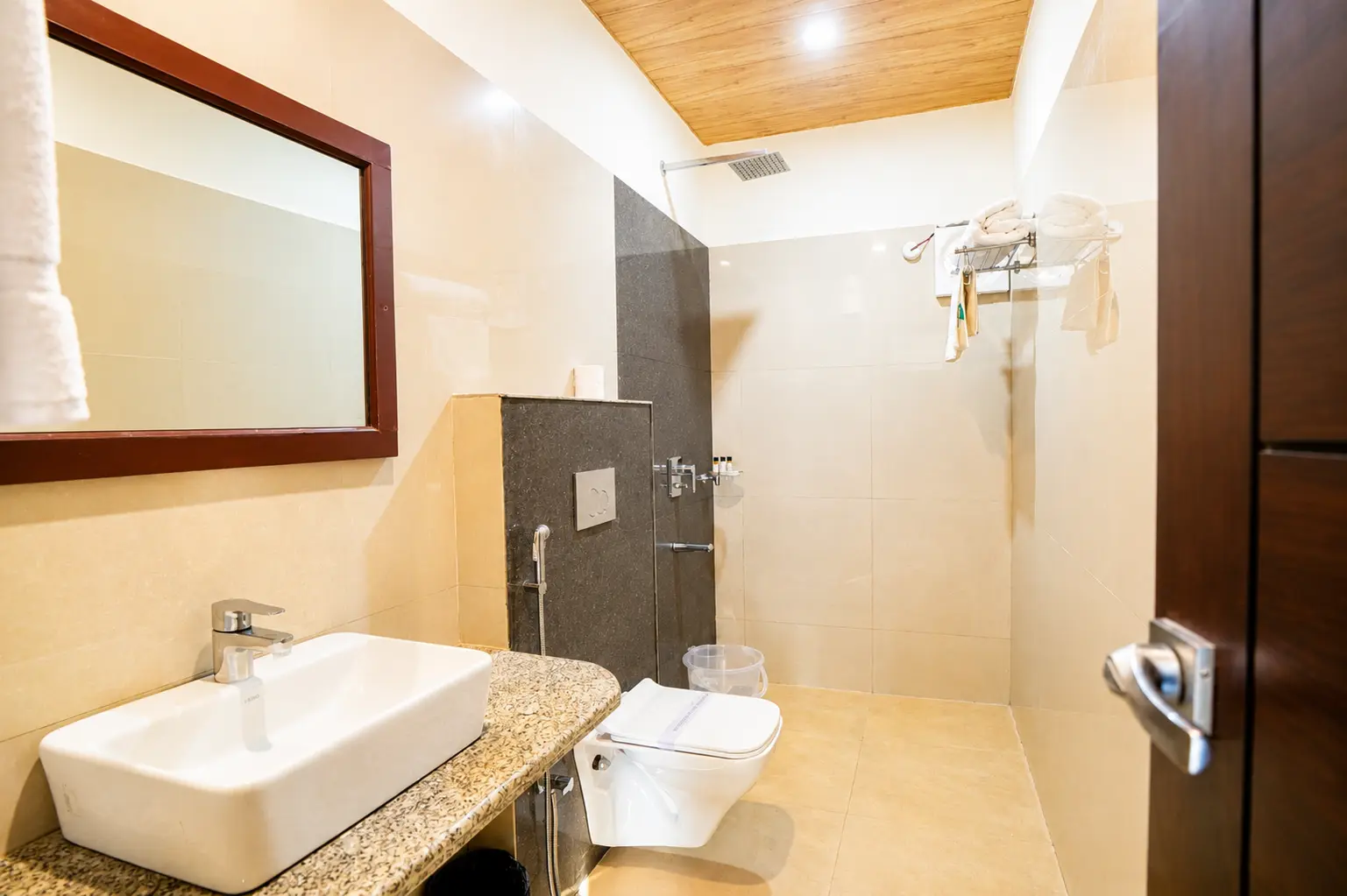 Cedar Room bathroom with modern vanity, shower area, mirror and toiletries at Excel Hotels and Resorts Corbett