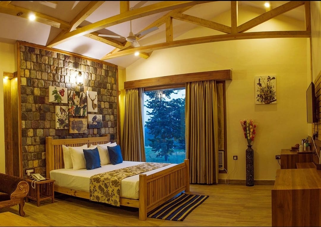 Banyan Cottage lounge area in Corbett with stone fireplace and gabled ceiling