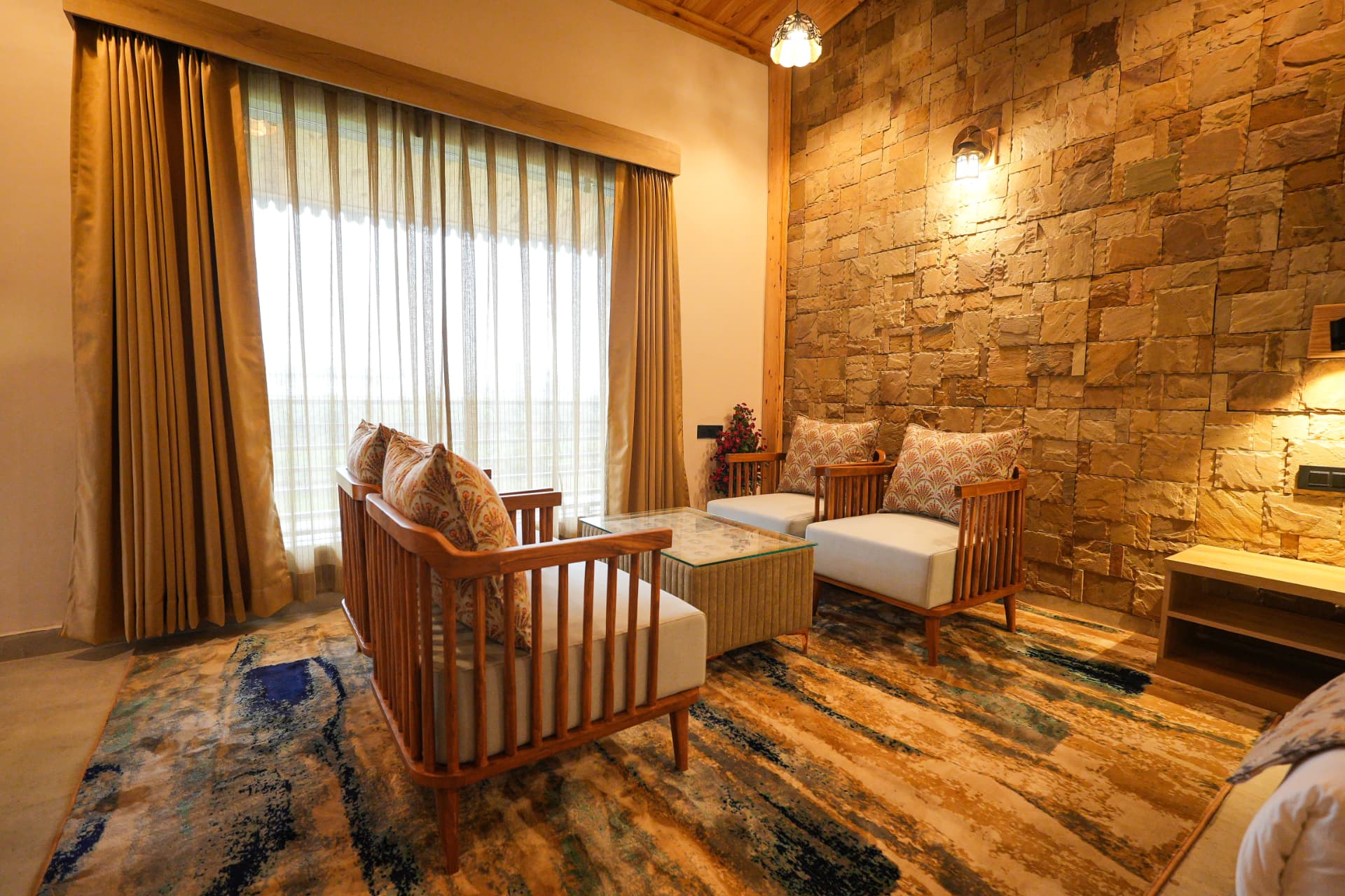 Kingfisher Suite interior at The Banyan Retreat with stone wall, timber accents and lounge
