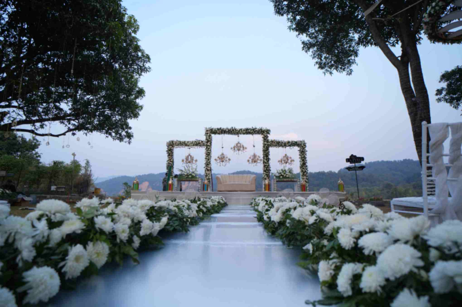 White floral aisle leading to the riverside wedding stage at La Perle River Resort