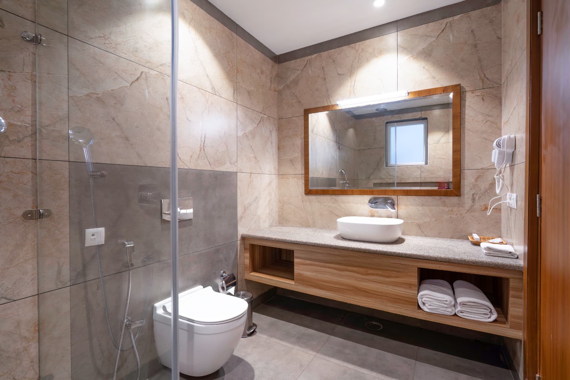 Premium Room modern bathroom with glass shower, vessel sink, mirror and warm lighting at Excel Hotels & Resorts, Kotabagh