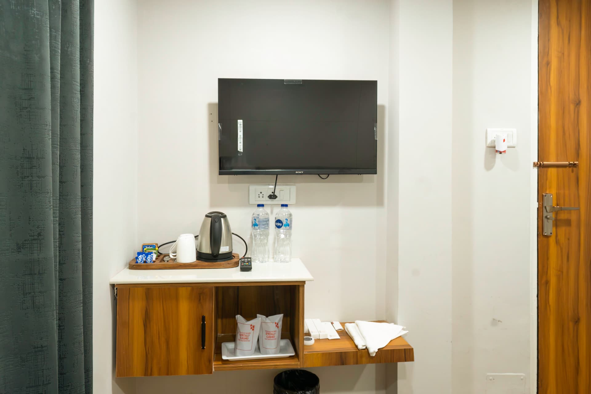 Deluxe Room amenities corner with TV, electric kettle, minibar area and bottled water