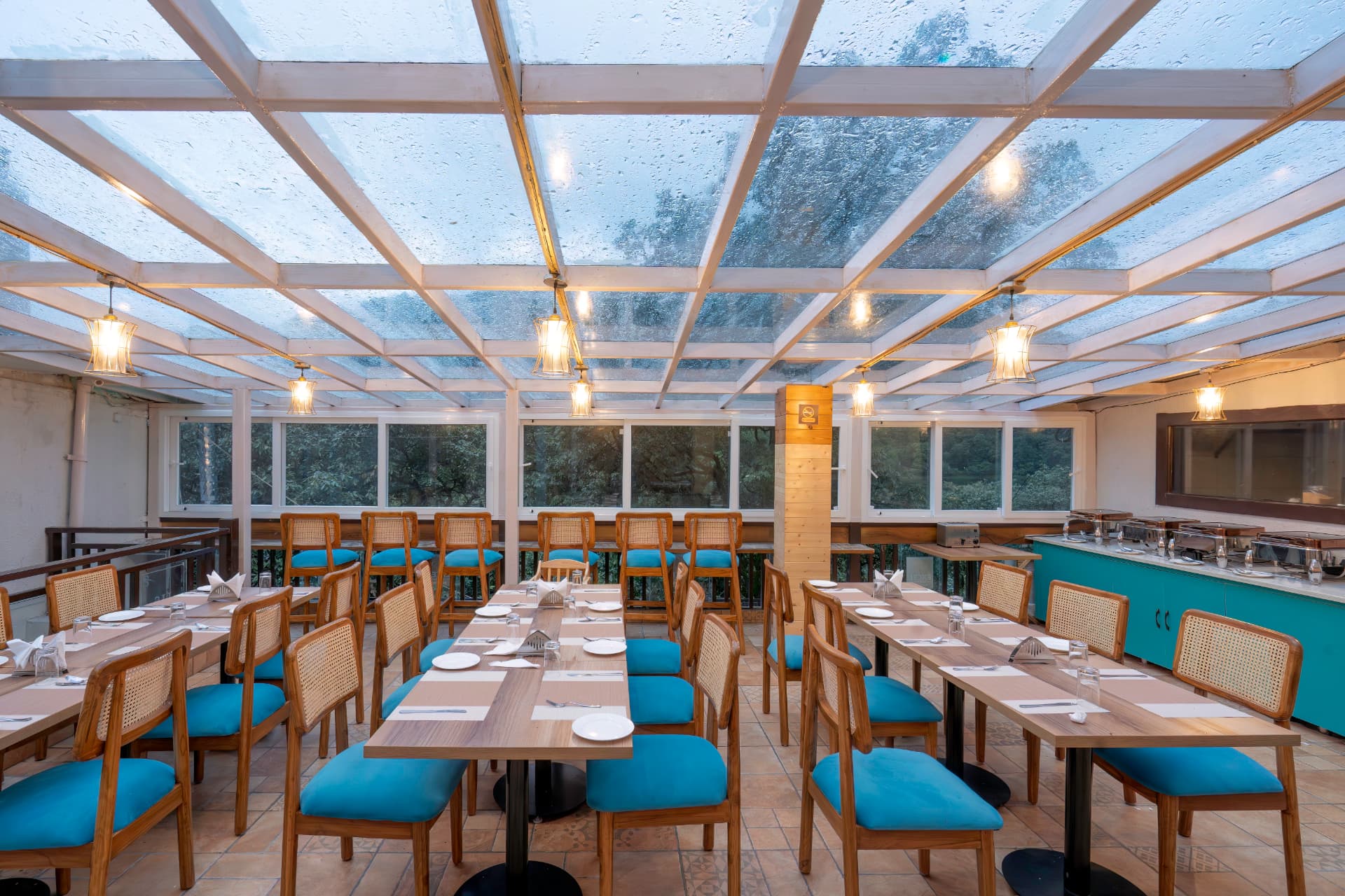 Elegant restaurant seating under a glass canopy at Foxo Cafe, Nainital