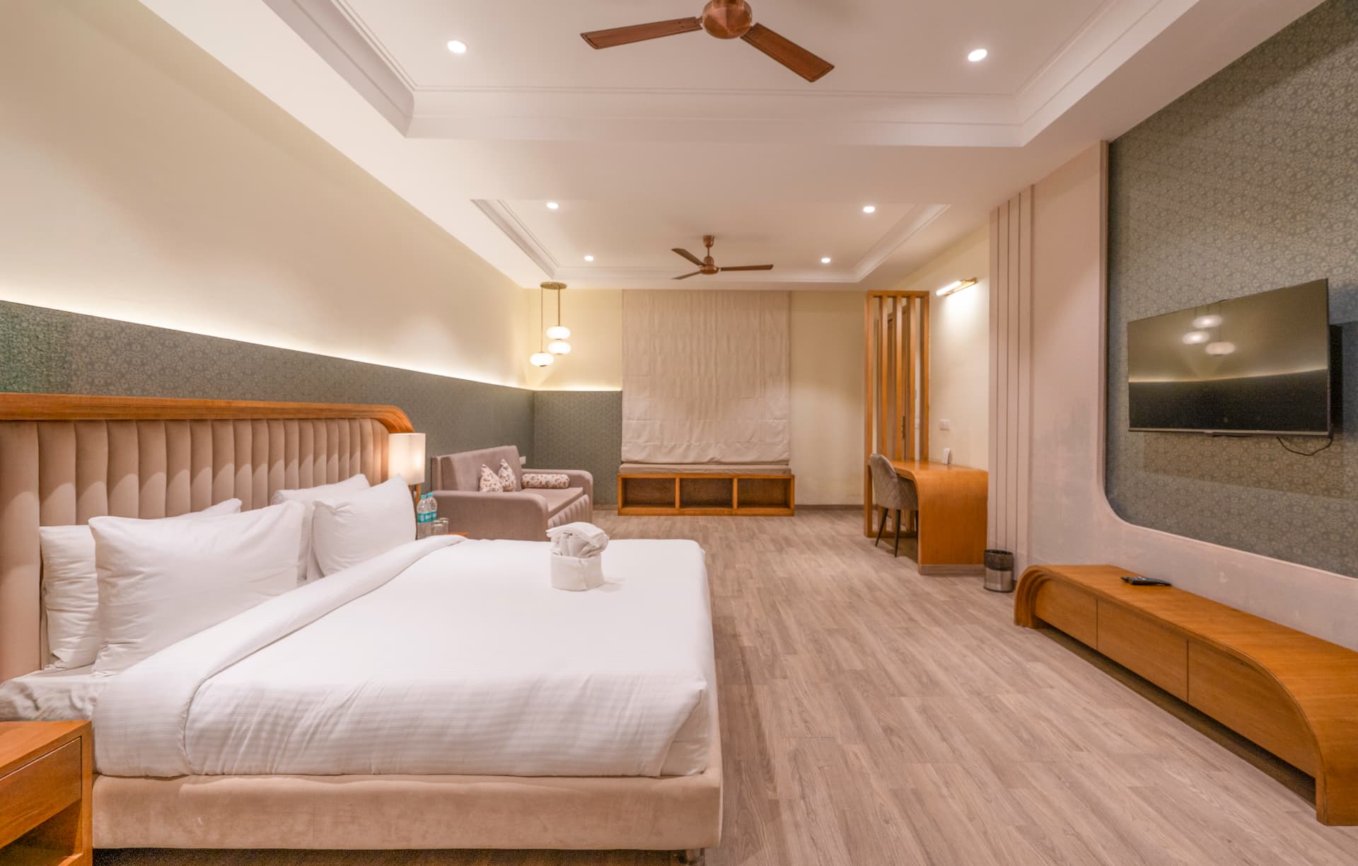 Premium Room bright interior with king bed, sofa, desk and modern wooden finishes at Excel Hotels & Resorts, Kotabagh