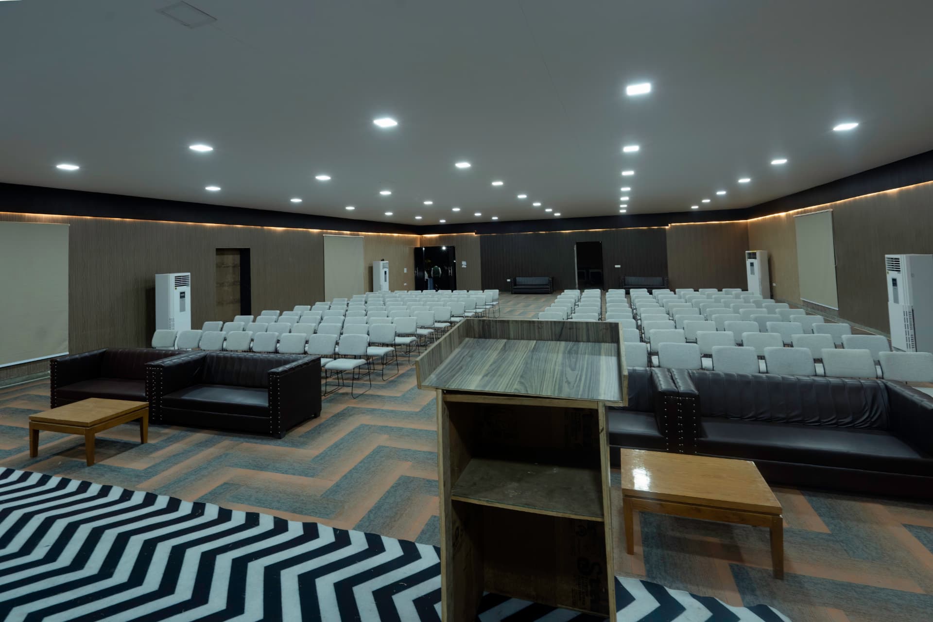 Amber pre-function area with lounge seating and podium at The Banyan Retreat