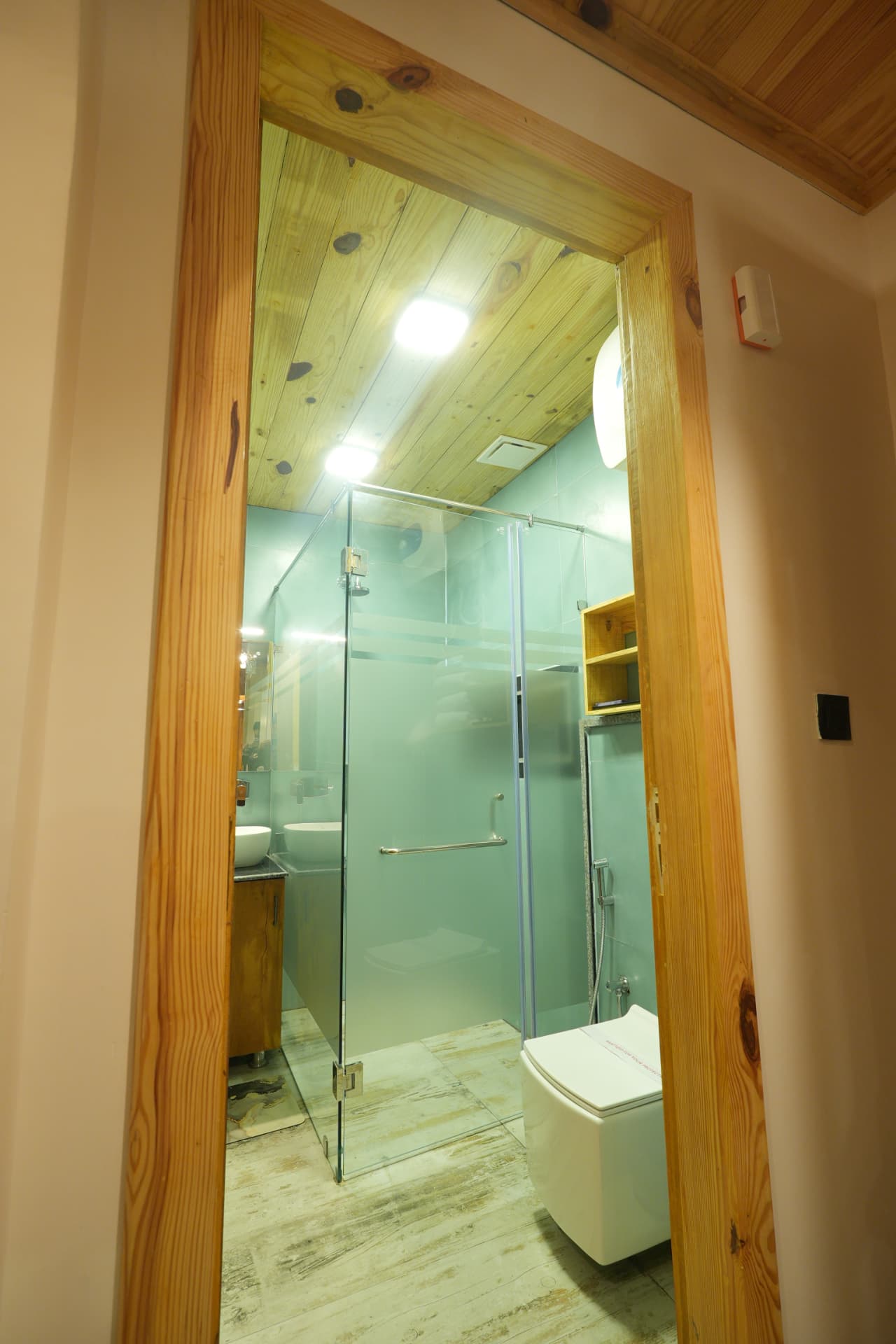 Modern bathroom with glass shower cabin and wooden finishes in the Weaver Bird Room