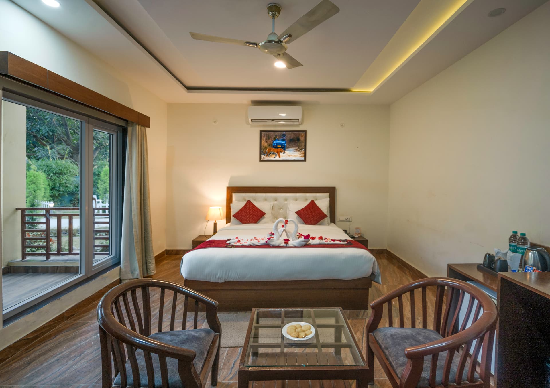 Pine Room interior with double bed, seating area and garden-window at Mango Bloom River Resort