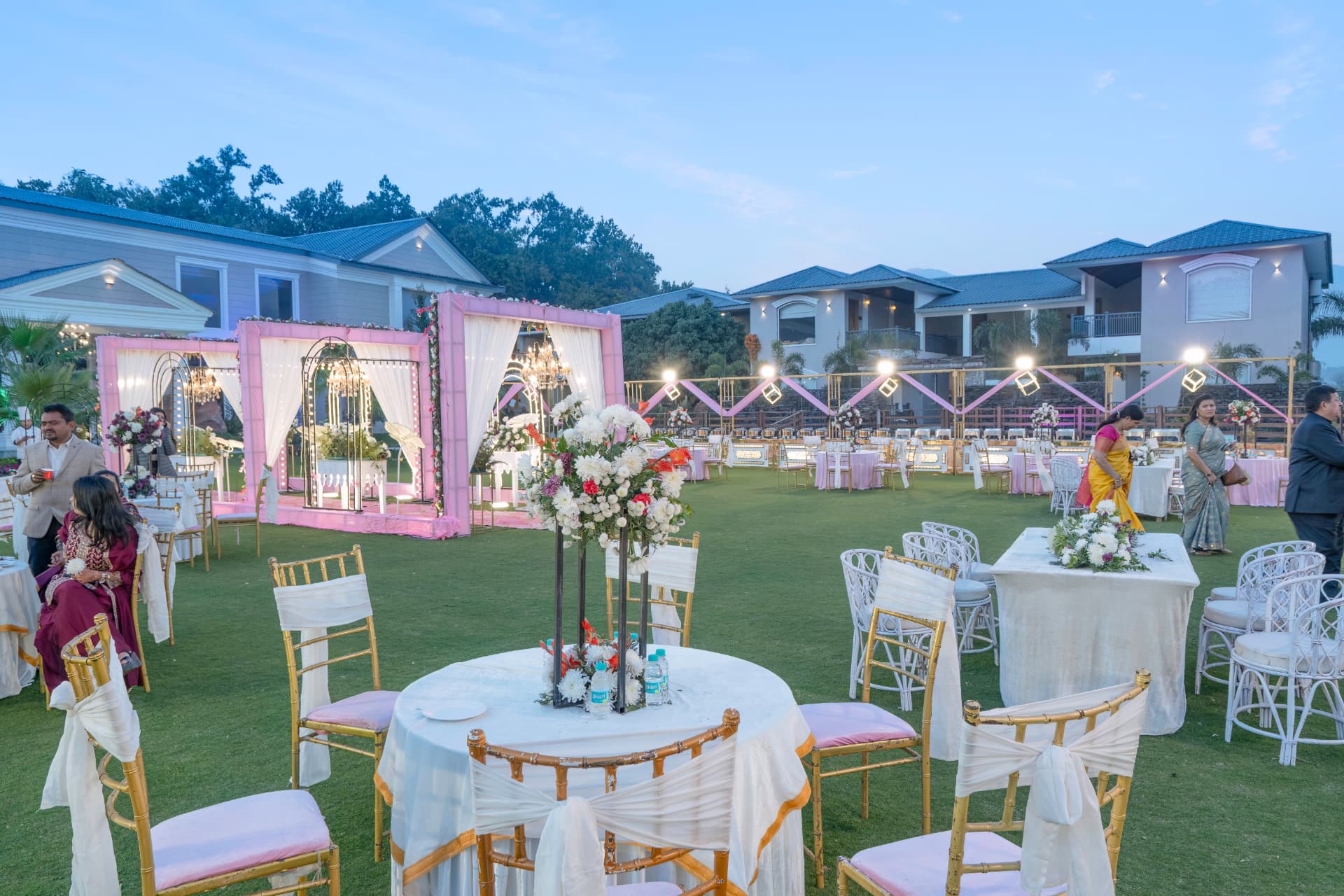 Outdoor wedding dinner setup with pink mandaps, tables and chairs at Excel Hotels & Resorts, Corbett