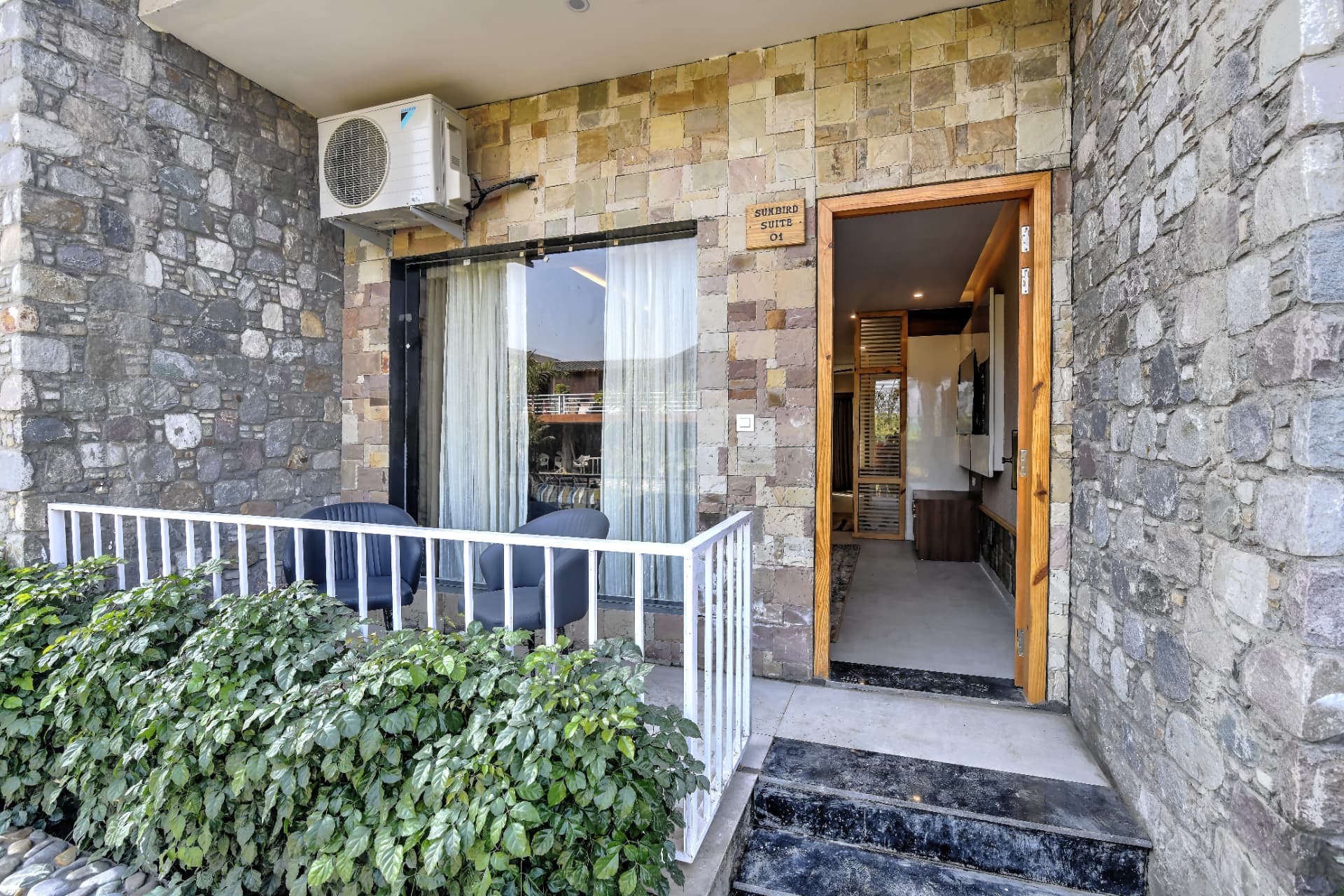 Sunbird Suite stone-clad private entrance with balcony seating at The Banyan Retreat