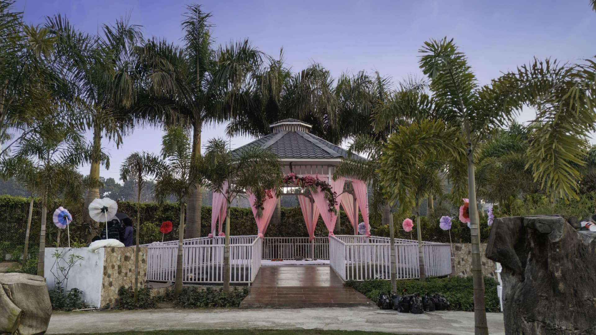 Decorated garden gazebo with pink drapes set among palm trees at Excel Hotels & Resorts, Kotabagh