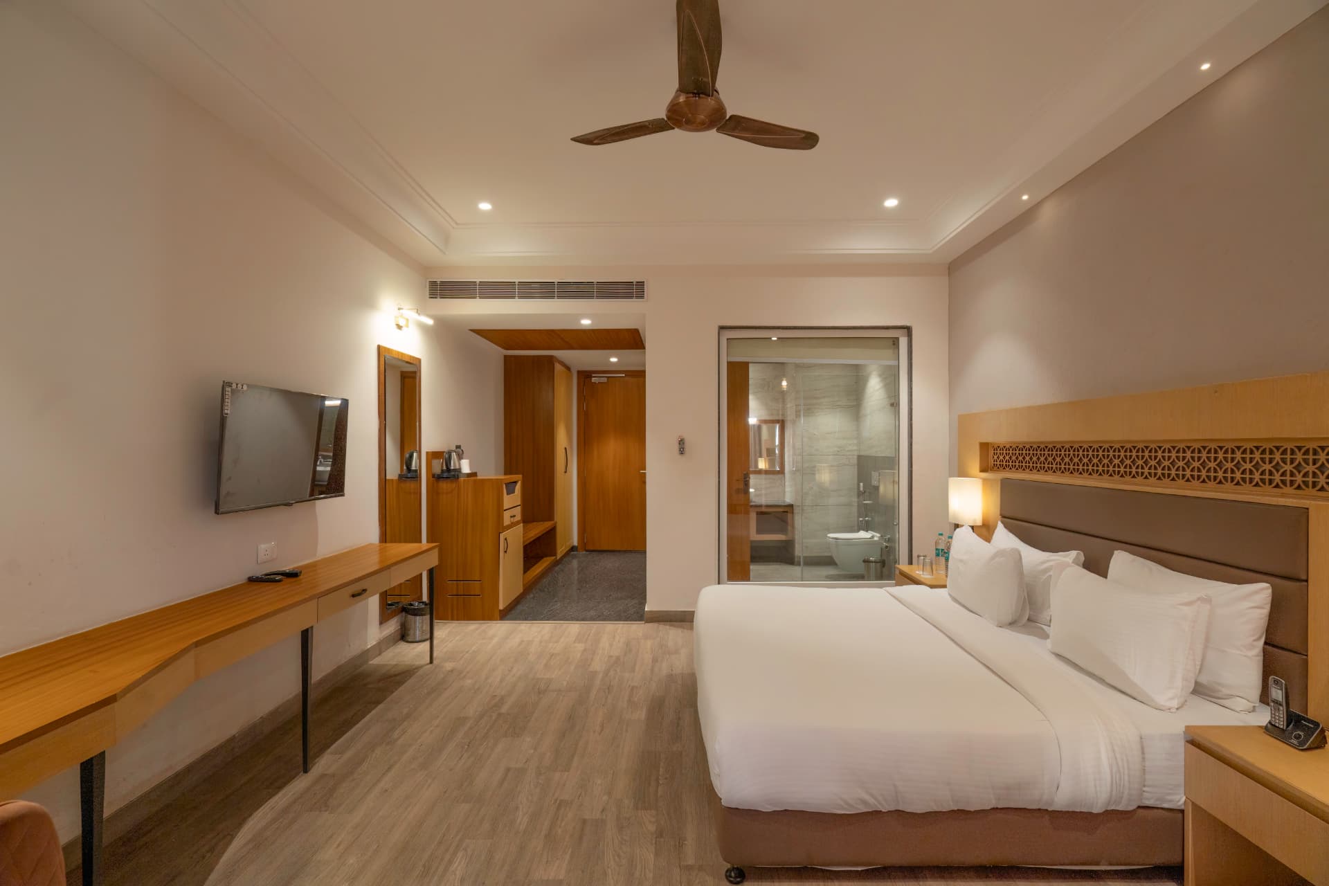 Deluxe Room wide view with TV, wardrobe, glass bathroom and king bed at Excel Hotels & Resorts, Kotabagh