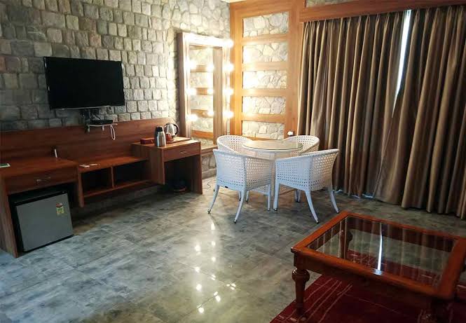 SplitsVilla room work desk, mini fridge, LED TV and lit vanity mirror