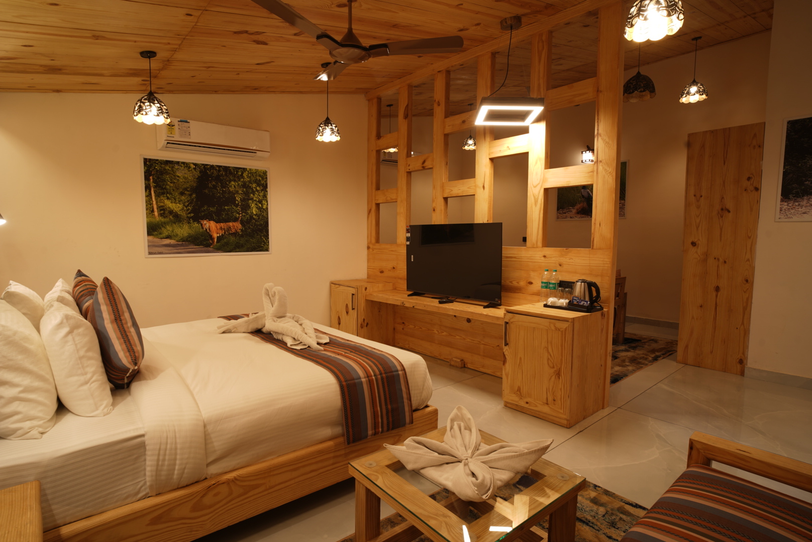 Rudraksh Suite bed with adjoining lounge seating and wooden partition in Jim Corbett