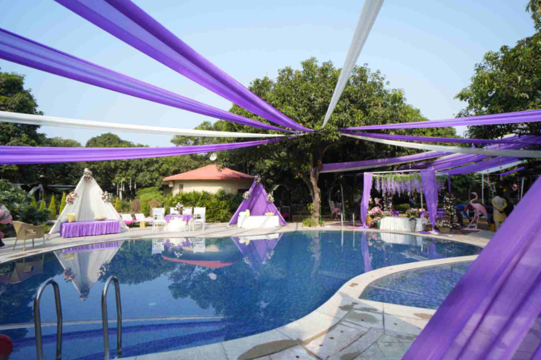 Poolside celebration with purple and white drapes at La Perle River Resort