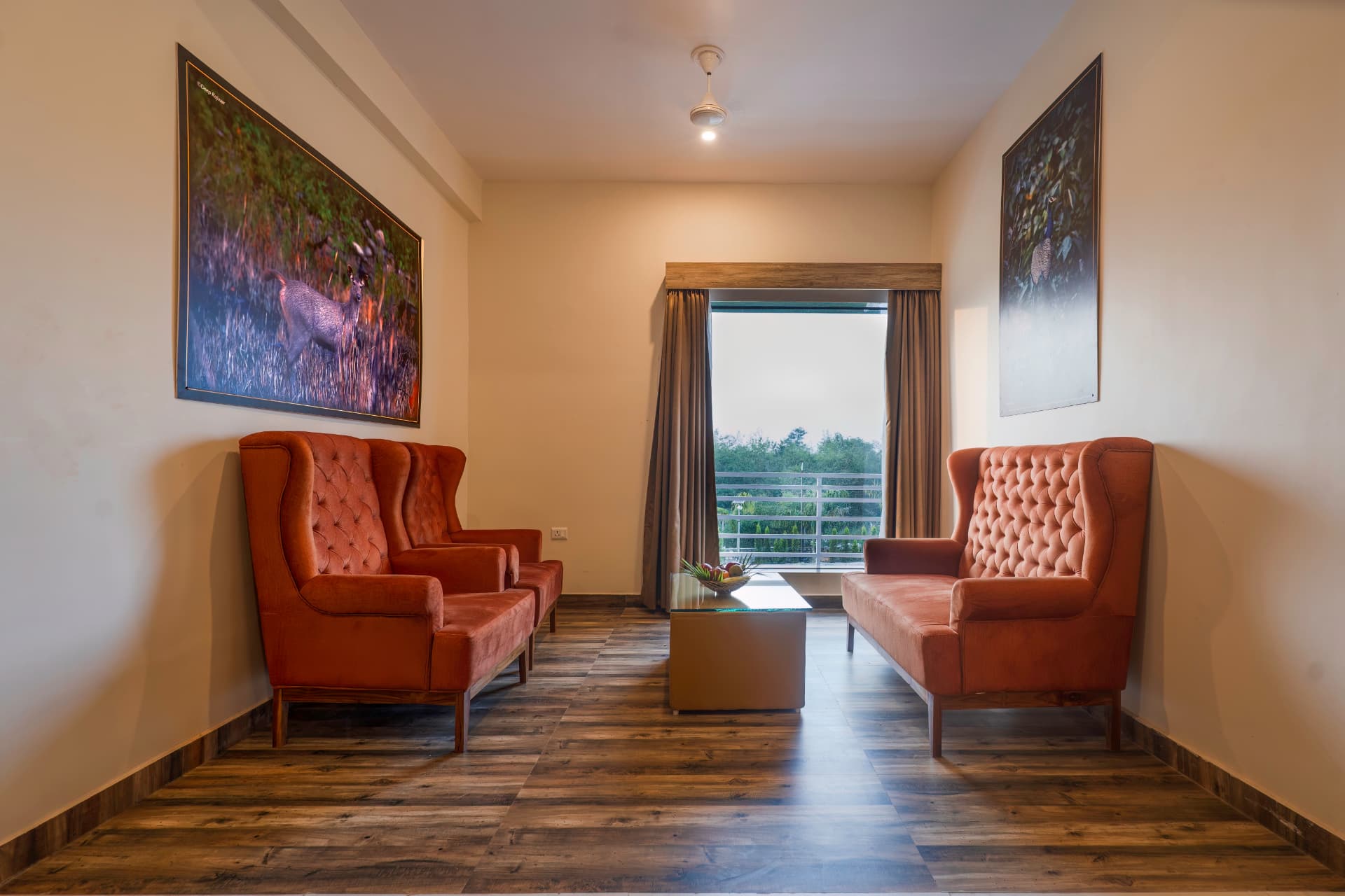 Kosi Suites sitting room with matching upholstered chairs, artwork and window at The Banyan Retreat, Corbett