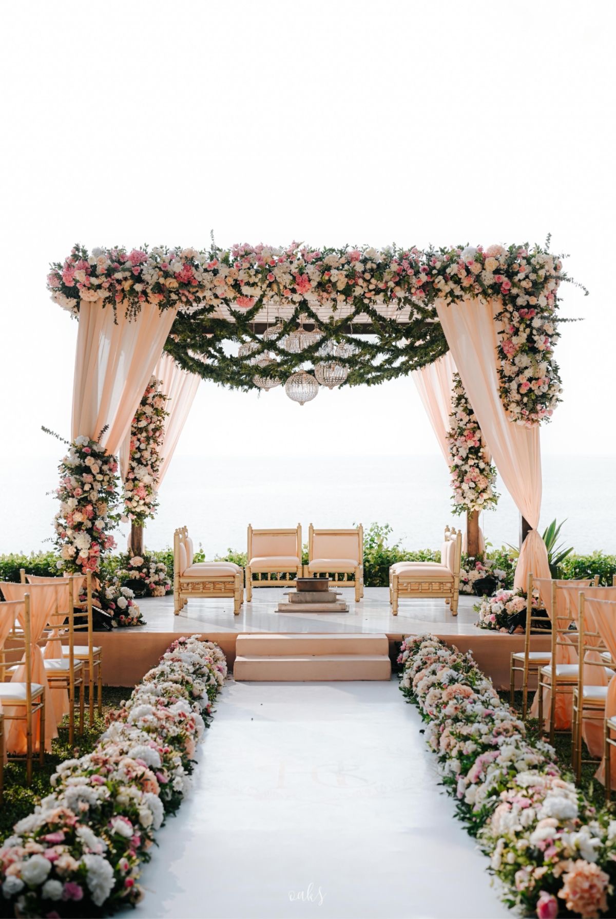 Floral mandap with draped canopy and petal-lined aisle at La Perle River Resort