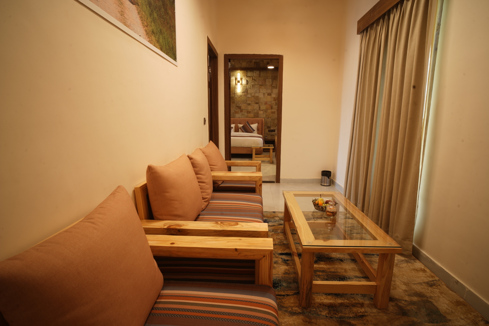 Ficus Suite lounge seating with sofa, coffee table and view into the bedroom