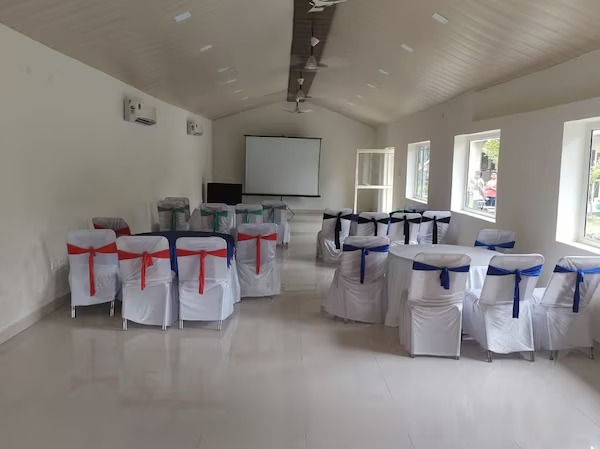 Conference room with projector screen and round-table seating at La Perle River Resort, Jim Corbett