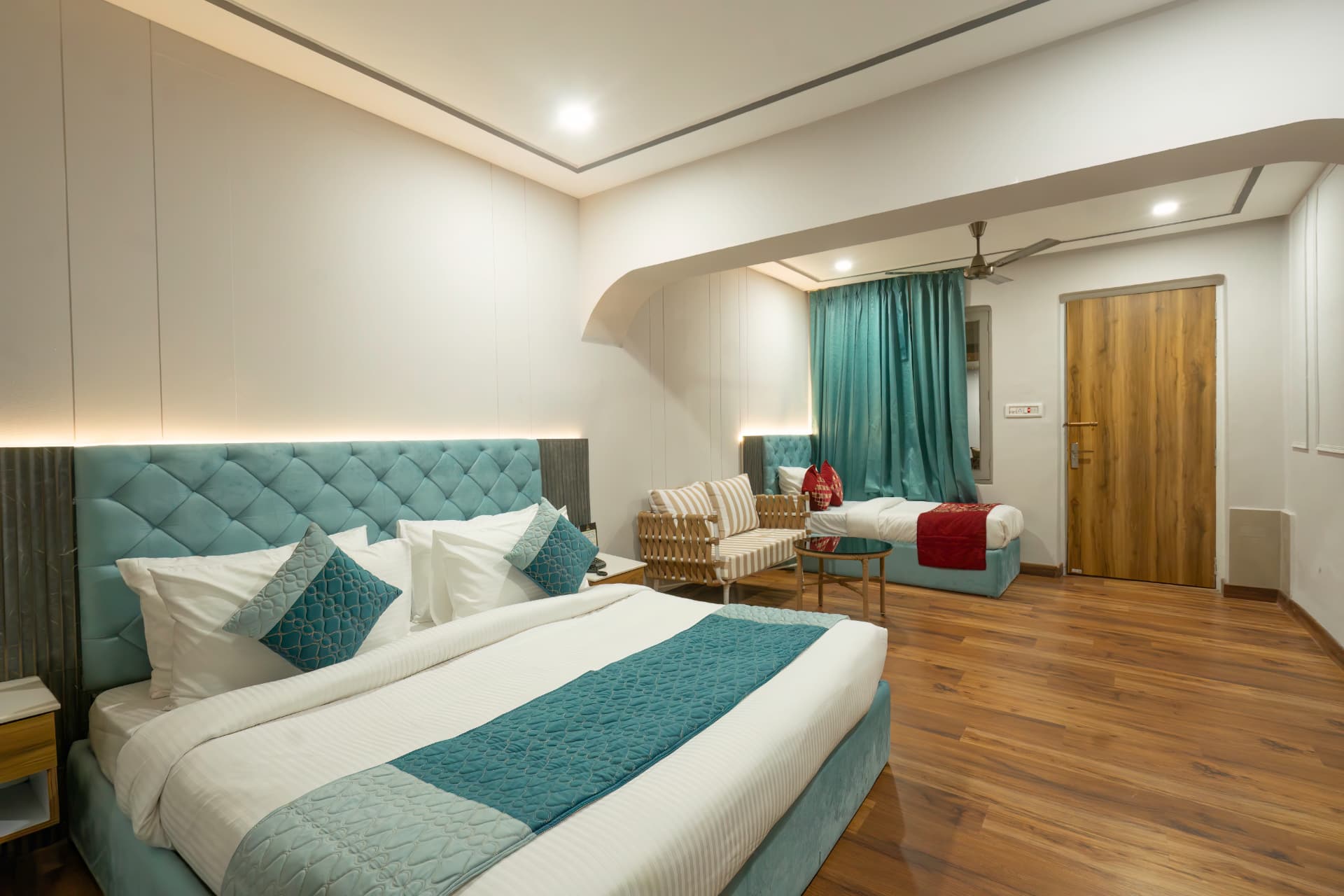 Junior Suite with king bed, turquoise headboard and additional single bed at Excel Hotels & Resorts Nainital