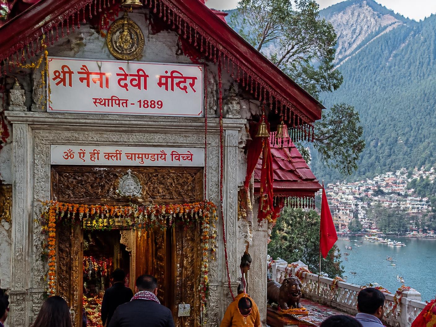 Entrance of Naina Devi Temple with intricate carvings and the lake visible behind