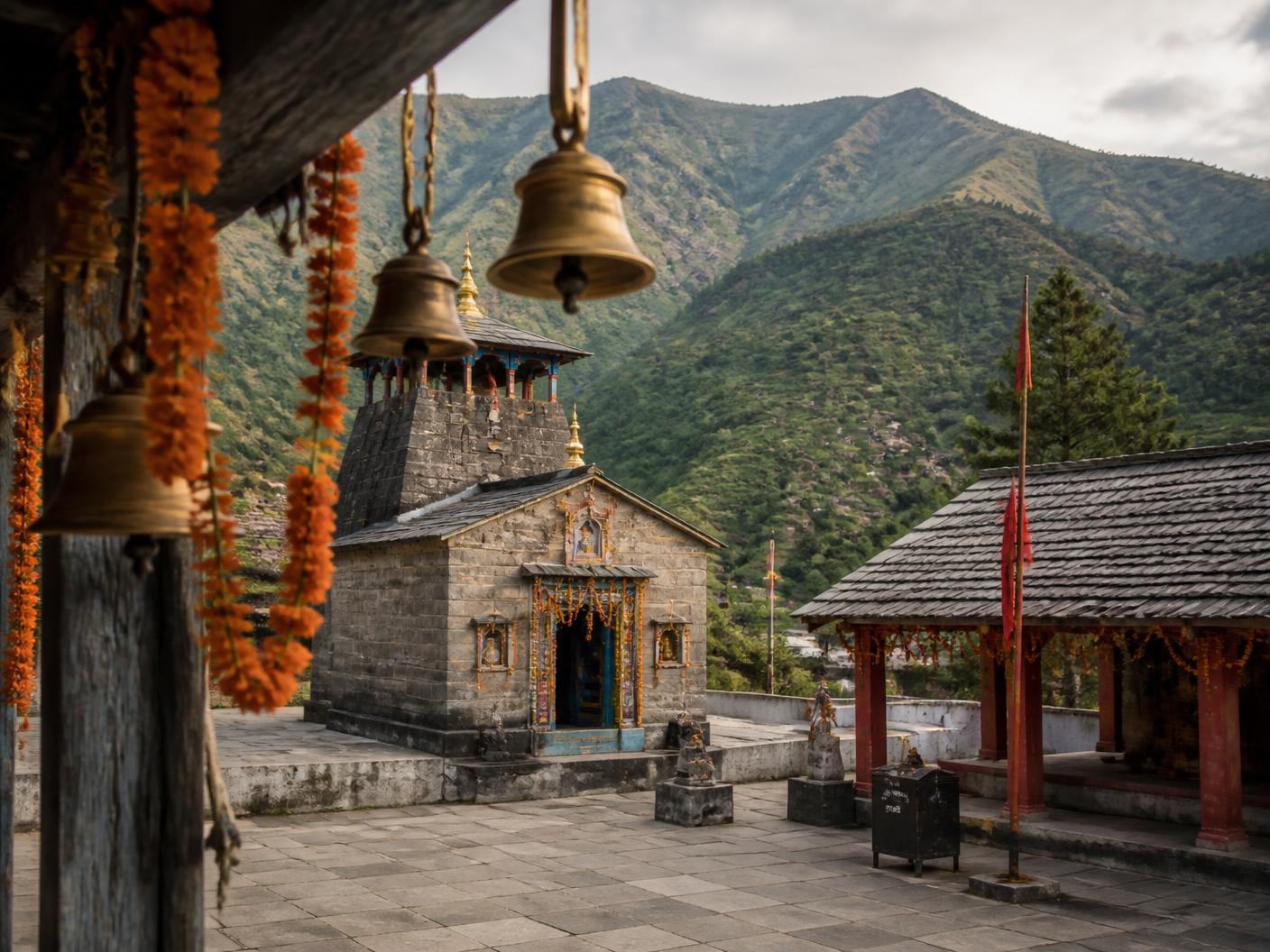 Temple courtyard with prayer bells and marigold garlands in the hills near Kainchi Dham